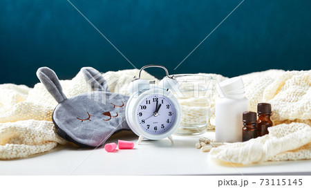 Sleeping mask, alarm clock, earplugs and pills. Healthy night sleep creative concept. 73115145