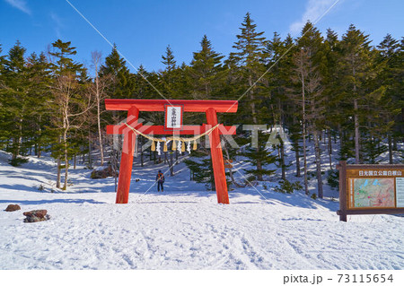 群馬県 冬の日光白根山登山口の二荒山神社鳥居と登山者 73115654