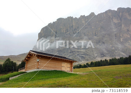 A small house against the backdrop of the Dolomites in Italy. 73118559