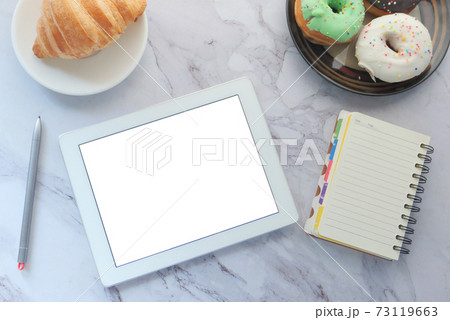 top view of digital tablet , donuts with suppliers on table top view of digital tablet , donuts with suppliers on table 73119663