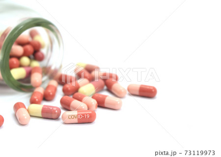 Medicine capsule covid-19 and bottle on white background. Focus on pills 73119973