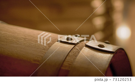 Old wine barrels in a wine cellar.  Stacked up wine bottles in the cellar, dusty but tasty. 73120253