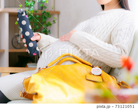 折りたたみ傘を準備する妊婦　4:3 73121051