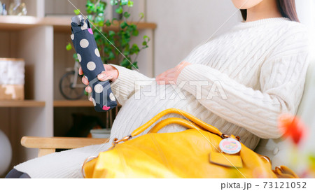 折りたたみ傘を準備する妊婦　16:9 73121052