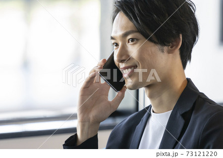 スマートフォンで通話する若い男性 73121220