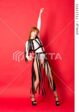 Young beautiful dancer posing in studio on red background 73121955