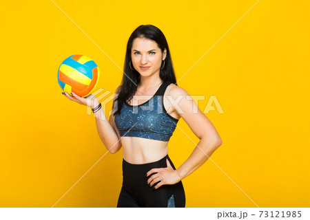 Young beautiful volleyball player isolated on yellow in studio 73121985