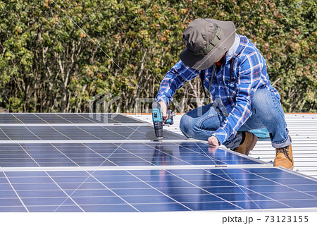 man installing solar panels on a home rooftop for alternative energy photovoltaic safe energy. power from nature sun power solar cell generator. 73123155