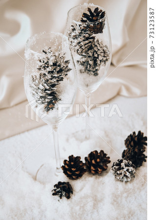 Champagne glasses with decorated pine cones on white snow. Christmas decorations. Happy new year. Copy space. Candles. DIY. zero waste christmas Champagne glasses with decorated pine cones on white snow. Christmas decorations. Happy new year. Copy space. Candles. DIY. zero waste christmas 73123587