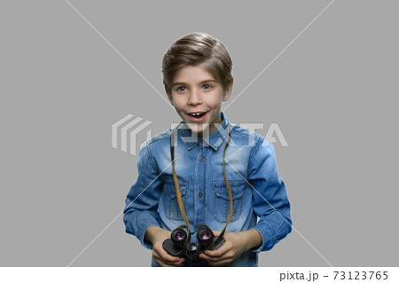 Excited preteen boy using binoculars. 73123765
