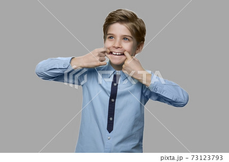 Child boy making funny pulling face with fingers in mouth. Child boy making funny pulling face with fingers in mouth. 73123793
