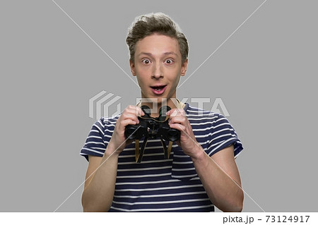 Surprised happy teen boy holding binoculars. Surprised happy teen boy holding binoculars. 73124917