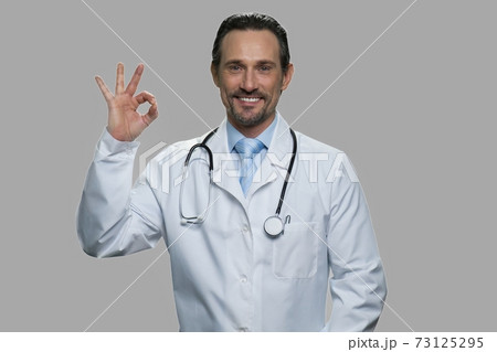 Portrait of handsome doctor showing ok sign. Portrait of handsome doctor showing ok sign. 73125295