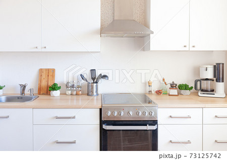 Scandinavian classic minimalistic kitchen with white and wooden details. Modern white kitchen clean contemporary style interior design. 73125742