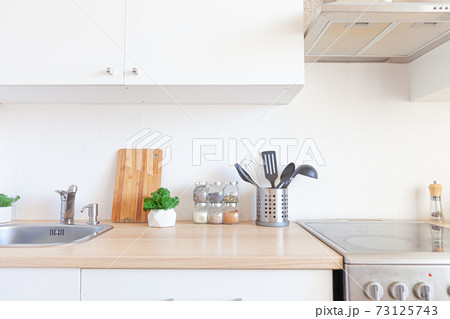 Scandinavian classic minimalistic kitchen with white and wooden details. Modern white kitchen clean contemporary style interior design. 73125743