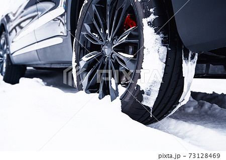 Car with winter tires on light-alloy wheels on the snow Car with winter tires on light-alloy wheels on the snow 73128469