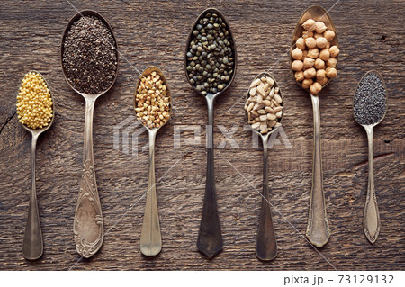 Chia, millet, chickpeas, poppy and other seeds and legumes on seven vintage spoons - top view Chia, millet, chickpeas, poppy and other seeds and legumes on seven vintage spoons - top view 73129132