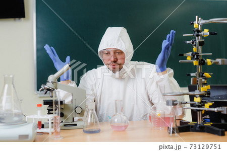 A scientist in a chemical laboratory is disappointed by a failed experiment with chemicals 73129751