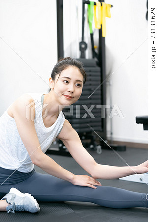 ジムでストレッチする若い女性 73131629