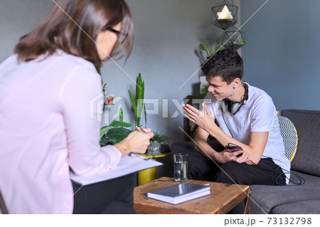 Teen boy talking to psychologist, individual therapy session for teenage with doctor Teen boy talking to psychologist, individual therapy session for teenage with doctor 73132798
