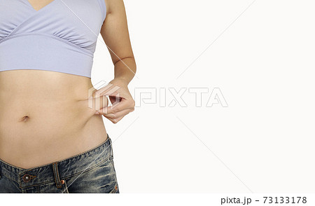 お腹ぽっこり ダイエットしたい女性 横長背景の写真素材