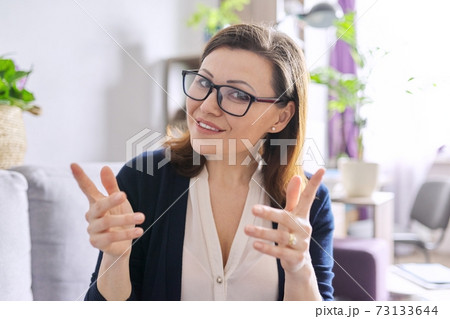 Female mentor, tutor, teacher looking at webcam of laptop, closeup face 73133644