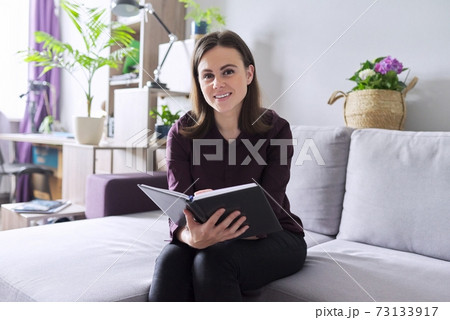 Portrait of young confident smiling female consultant, psychologist with business notebook Portrait of young confident smiling female consultant, psychologist with business notebook 73133917