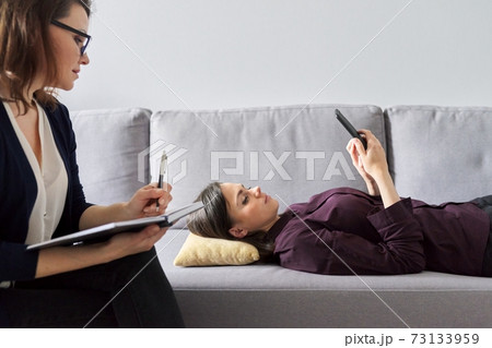 Young woman at consultation with psychologist. Female patient lying on couch 73133959