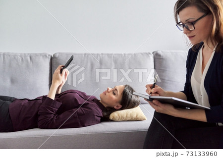 Young woman at consultation with psychologist. Female patient lying on couch Young woman at consultation with psychologist. Female patient lying on couch 73133960