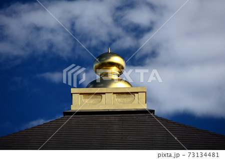 お寺の屋根に金色に輝く宝珠 73134481
