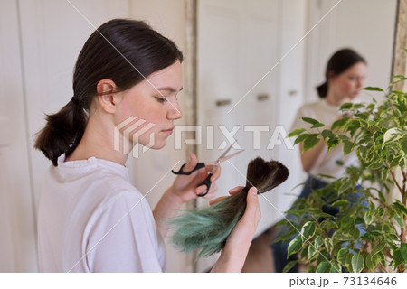 Girl makes a haircut at home, teenager cut her hair 73134646
