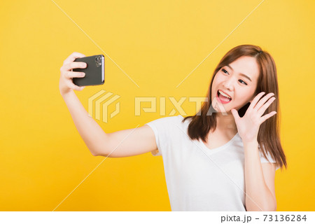 woman teen smiling standing wear t-shirt making selfie photo, video call on smartphone 73136284