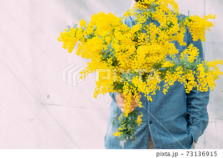 ミモザの花束を持つ男性の写真素材