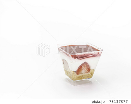 The close up of strawberry cheesecake in transparent plastic square shape cup isolated on white background. The close up of strawberry cheesecake in transparent plastic square shape cup isolated on white background. 73137377