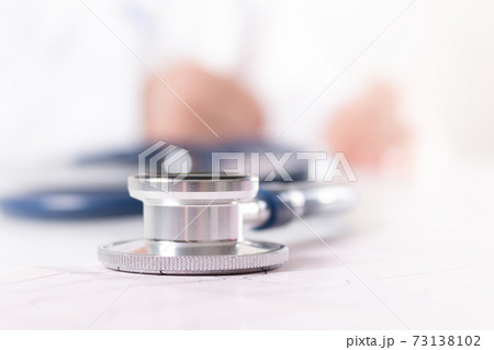 Close-up stethoscope. Blurred doctor in white uniform. Close-up stethoscope. Blurred doctor in white uniform. 73138102