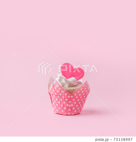Valentines cupcake with a pink heart shaped cake pick on a pink background, Saint Valentine romance monochrome concept, sweet food, birthday, girl seasonal holiday party, flyer, invitation Valentines cupcake with a pink heart shaped cake pick on a pink background, Saint Valentine romance monochrome concept, sweet food, birthday, girl seasonal holiday party, flyer, invitation 73138997
