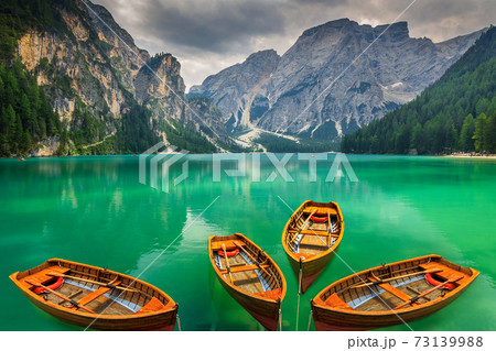 Beautiful mountain lake with wooden boats in the Dolomites,Italy Beautiful mountain lake with wooden boats in the Dolomites,Italy 73139988