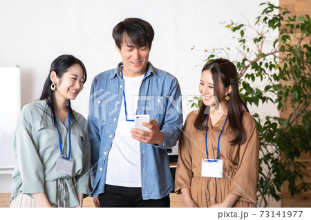 スマホを見る男女の会社員 73141977