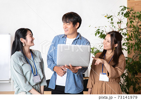 ノートパソコンをみる男女の会社員 73141979