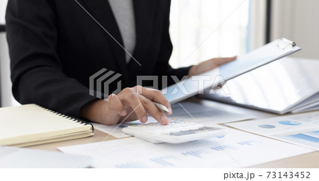 Accounting businesswomen are calculating income-expenditure and analyzing real estate investment data, Dedicated to the progress and growth of the company, Financial and tax systems concept. 73143452