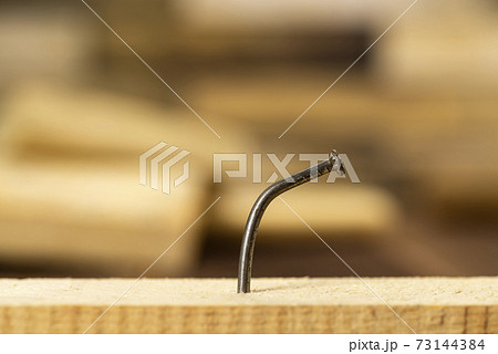 Wooden plank with one bent nail, locksmith workshop 73144384