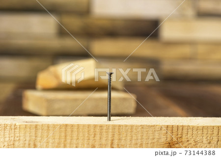 Close-up of a single nail stuck in a wooden board Close-up of a single nail stuck in a wooden board 73144388