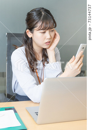 スマホ画面を見て困っている女性 73144737