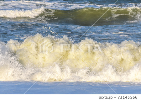 Waves breaking on the beach at the edge of the Atlantic Ocean. 73145566