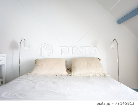 Bed and lamp in a white bedroom 73145912