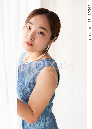 窓の前に立つドレスを着た女性 73149545