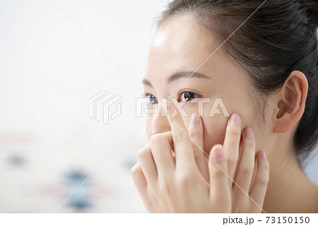 コンタクトレンズを入れる若い女性 73150150