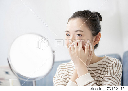 コンタクトレンズを入れる若い女性 73150152