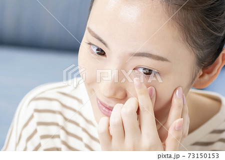 コンタクトレンズを入れる若い女性 73150153