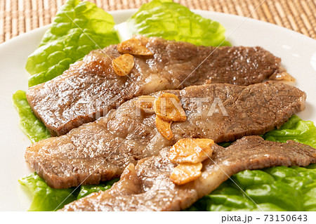 国産黒毛和牛カルビ焼肉。サンチュの上に盛り付け(にんにくチップのせ)。 国産黒毛和牛カルビ焼肉。サンチュの上に盛り付け(にんにくチップのせ)。 73150643